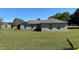 Spacious backyard showcasing the home's exterior and expansive lawn with mature trees at 3171 Santa Cruz Dr, Kissimmee, FL 34746