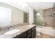 Bathroom with dual vanity, granite countertops, framed mirror and glass doors to the shower/tub at 3252 Toscana Dr, St Cloud, FL 34772