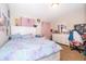 Bedroom with large bed with colorful bedspread, white dresser, and pink curtains in front of window at 3252 Toscana Dr, St Cloud, FL 34772