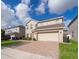 A two-story home with a two-car garage and a brick driveway in a residential neighborhood at 3252 Toscana Dr, St Cloud, FL 34772