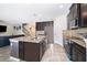 Well-appointed kitchen with an island, dark cabinetry, granite counters, and modern appliances at 3252 Toscana Dr, St Cloud, FL 34772