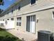 A townhouse backyard with a brick patio, sliding glass door, and central air conditioning unit at 3561 Sanctuary Dr, St Cloud, FL 34769