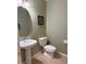 Half bathroom featuring a pedestal sink, a round mirror, neutral paint, and a comfort height toilet at 3561 Sanctuary Dr, St Cloud, FL 34769