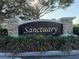 A stone sign with elegant lettering that reads 'Sanctuary', set amidst manicured greenery at 3561 Sanctuary Dr, St Cloud, FL 34769