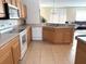 Well-equipped kitchen with wood cabinetry, modern appliances, and an open layout that connects to the living area at 3561 Sanctuary Dr, St Cloud, FL 34769