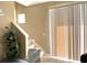 Bright interior view of the carpeted staircase, bathed in sunlight, adjacent to a sliding glass door with vertical blinds at 3561 Sanctuary Dr, St Cloud, FL 34769