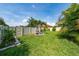 Landscaped backyard featuring lush green grass, palm trees, and white fence at 4007 Green Sabal Dr, Orlando, FL 32824