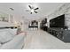 Open living room with gray sofa, brick accent wall, tiled floor, and view to the kitchen at 4007 Green Sabal Dr, Orlando, FL 32824