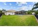Spacious backyard with lush green lawn, screened in pool and patio at 4125 Navigator Way, Kissimmee, FL 34746