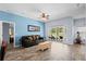 Spacious living room with light blue walls, ceiling fan, and wood-look flooring at 4125 Navigator Way, Kissimmee, FL 34746