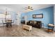 Open-concept living room with light blue accent walls and wood-look flooring at 4125 Navigator Way, Kissimmee, FL 34746