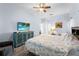 Cozy main bedroom with ceiling fan, wood-look floors, and an entertainment center with a large-screen TV at 4125 Navigator Way, Kissimmee, FL 34746