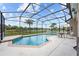 Beautiful backyard pool with a screen enclosure and well-manicured landscaping with lake view at 4125 Navigator Way, Kissimmee, FL 34746