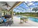 The screened-in pool features a hot tub, a patio table with chairs, and lounge chairs at 4125 Navigator Way, Kissimmee, FL 34746