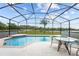 The screened-in pool features a patio table with chairs and views of the backyard at 4125 Navigator Way, Kissimmee, FL 34746