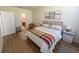 Brightly-lit bedroom featuring wood flooring, light walls, a decorative rug, and an ensuite bathroom at 4525 Sw 52Nd Cir # 103, Ocala, FL 34474