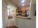 View of the kitchen with stainless steel appliances, wood cabinets, and a pass-through to the dining area at 4525 Sw 52Nd Cir # 103, Ocala, FL 34474