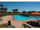 Community pool with brick deck, lounge chairs, and umbrellas under a bright, sunny sky at 4525 Sw 52Nd Cir # 103, Ocala, FL 34474