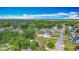 Residential aerial view featuring tree-lined streets and a lake in the background at 4765 Lake Shore Dr, St Cloud, FL 34772