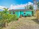 Quaint backyard featuring a vibrant turquoise home exterior and space for gardening at 4765 Lake Shore Dr, St Cloud, FL 34772
