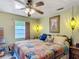 Comfortable bedroom with a colorful patchwork quilt, vintage lamps, and a ceiling fan at 4765 Lake Shore Dr, St Cloud, FL 34772