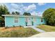 Inviting turquoise home with a tidy front lawn, complemented by tasteful landscaping at 4765 Lake Shore Dr, St Cloud, FL 34772