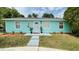 Charming single-story home featuring a vibrant turquoise exterior and well-maintained front yard at 4765 Lake Shore Dr, St Cloud, FL 34772