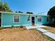 Light blue single-story home featuring a welcoming entrance and well-maintained front yard under a clear blue sky at 4765 Lake Shore Dr, St Cloud, FL 34772