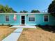 Charming, light blue single-story home featuring a welcoming entrance and well-maintained front yard under a clear blue sky at 4765 Lake Shore Dr, St Cloud, FL 34772
