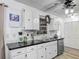 Bright kitchen with white cabinets, black countertops, and stainless steel dishwasher at 4765 Lake Shore Dr, St Cloud, FL 34772