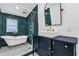 Elegant bathroom featuring a clawfoot tub, vanity, and dark green tile at 503 New York Ave, St Cloud, FL 34769