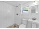 Modern bathroom featuring subway tile shower, pedestal sink, and window at 503 New York Ave, St Cloud, FL 34769
