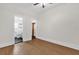 This bedroom features wood floors, a ceiling fan, and doors to a bathroom and closet at 503 New York Ave, St Cloud, FL 34769
