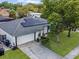 An aerial view of a single-story home featuring solar panels, manicured lawn and a two-car garage at 5123 Lighthouse Rd, Orlando, FL 32808