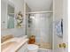 Bathroom featuring a tiled shower with sliding glass door, decorative accents, and a warm neutral palette at 5123 Lighthouse Rd, Orlando, FL 32808