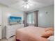 Inviting bedroom featuring a dresser, comfortable bed, and ample natural light at 5123 Lighthouse Rd, Orlando, FL 32808