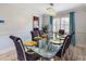 Elegant dining room featuring glass-top table with seating for eight, modern chandelier and hardwood floors at 5123 Lighthouse Rd, Orlando, FL 32808