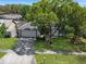 Home with solar panels, well-manicured lawn, and large mature trees at 5123 Lighthouse Rd, Orlando, FL 32808
