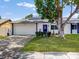 Charming single-story home with a well-maintained lawn, mature tree, and a two-car garage at 5123 Lighthouse Rd, Orlando, FL 32808