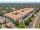 Sprawling apartment complex featuring a terracotta roof, lush landscaping, and ample parking at 5550 E Michigan St # 2214, Orlando, FL 32822