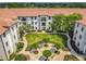 Stunning aerial view of condo complex showcasing lush courtyard and Spanish tile roof at 5550 E Michigan St # 2214, Orlando, FL 32822