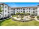 Charming courtyard featuring benches, mature trees, and meticulous landscaping in a white painted condo at 5550 E Michigan St # 2214, Orlando, FL 32822