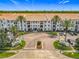 Beautiful apartment complex features lush landscaping, palm trees, and a welcoming entrance at 5550 E Michigan St # 2214, Orlando, FL 32822