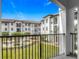 A manicured courtyard and white buildings are seen from this balcony view at 5550 E Michigan St # 2214, Orlando, FL 32822