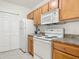 A well-lit kitchen with wooden cabinets and white appliances provides an efficient cooking space at 5550 E Michigan St # 2214, Orlando, FL 32822
