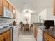 Kitchen featuring wooden cabinets, granite countertops, and white appliances at 5550 E Michigan St # 2214, Orlando, FL 32822