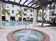 This community pool features tall palm trees, loungers, and a hot tub at 5550 E Michigan St # 2214, Orlando, FL 32822