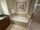 Bright bathroom featuring a soaking tub and glass enclosed shower with ceramic tile at 7658 Whisper Way # 203, Reunion, FL 34747
