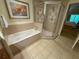 Bright bathroom featuring a soaking tub and glass enclosed shower with ceramic tile at 7658 Whisper Way # 203, Reunion, FL 34747