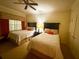This bedroom features two beds, ceiling fan and soft neutral colored walls at 7658 Whisper Way # 203, Reunion, FL 34747